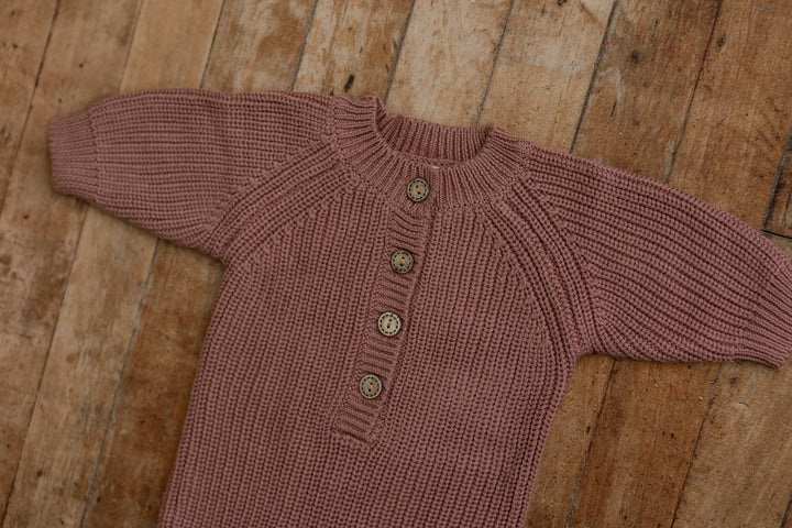 Close-up of plum knit sitter romper with detailed buttons, designed for sitter milestone photography.
