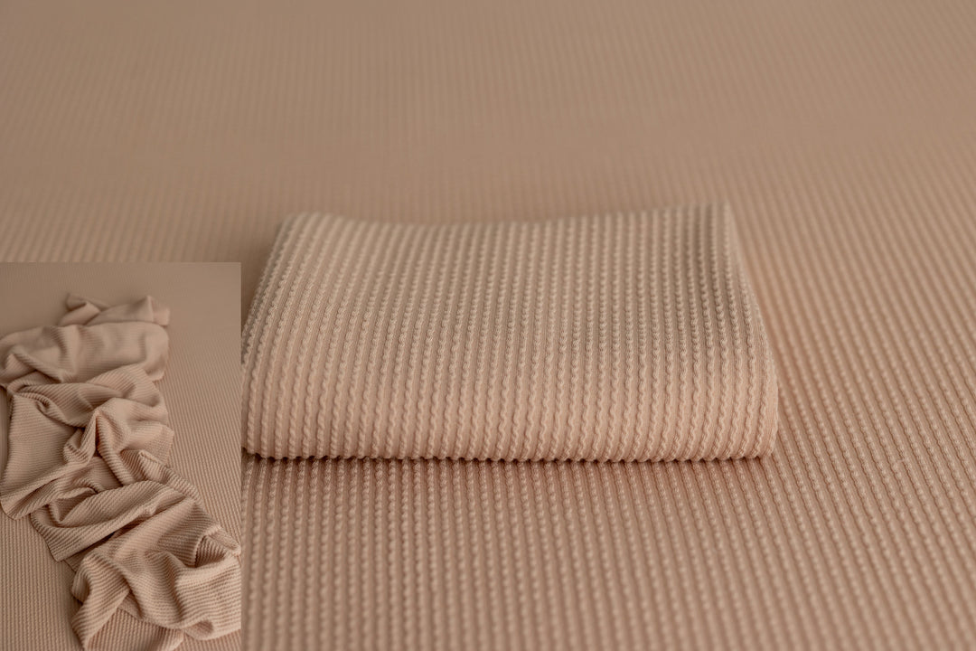 Neutral ribbed Primrose fabric and matching wrap in the color “Nipple,” styled for newborn photography props and layering.