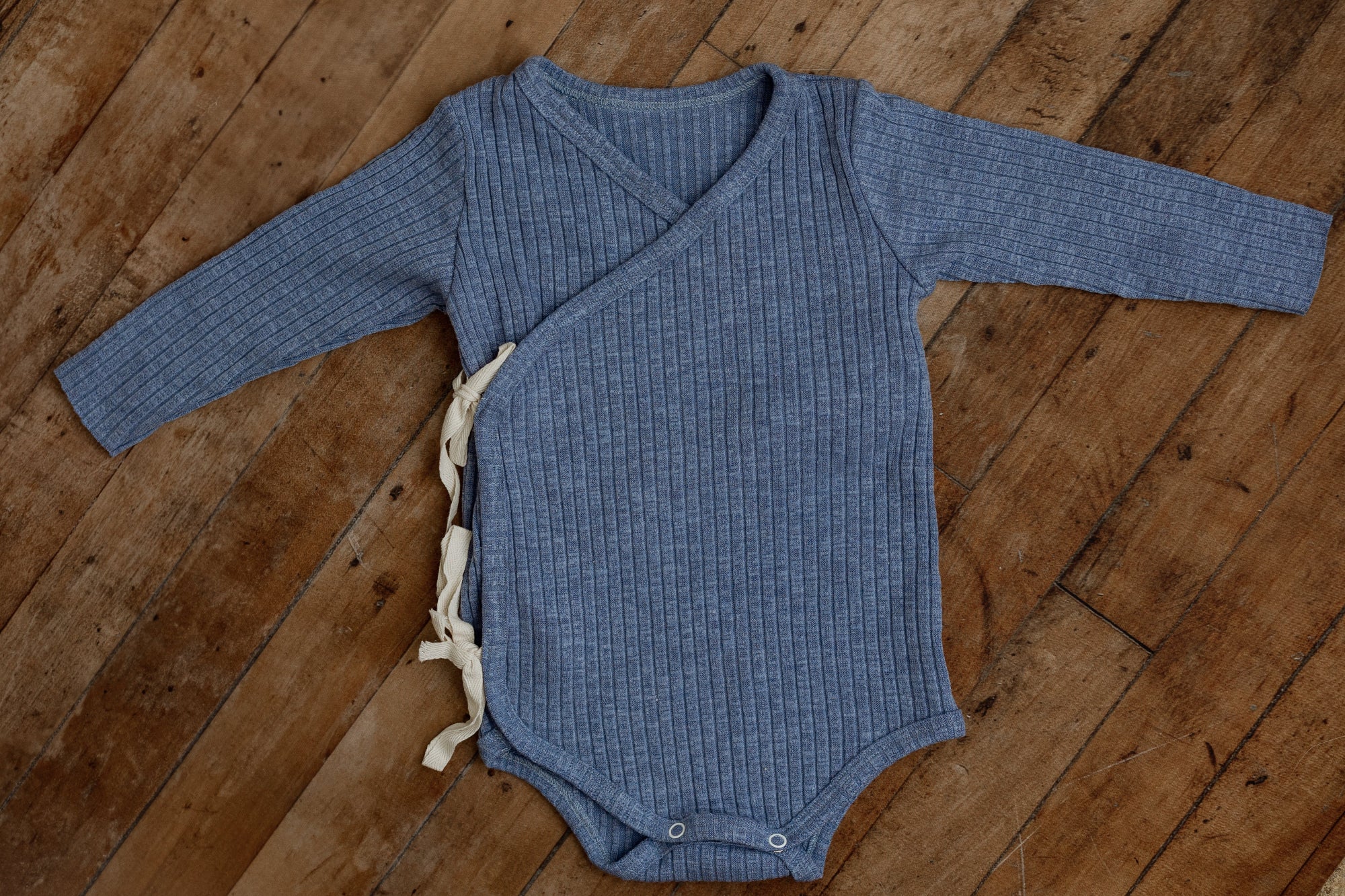 Sea Breeze ribbed kimono-style sitter romper with cream side ties and long sleeves, designed for 6–12 month milestone photography sessions.