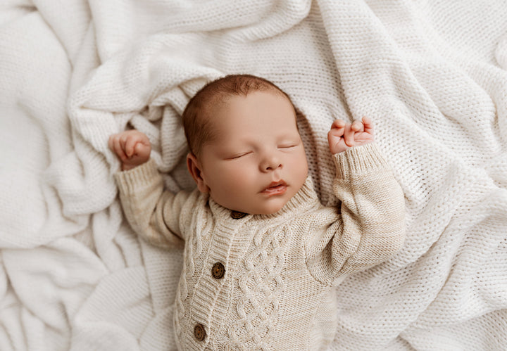 Newborn wearing the Woodland knit cardigan in taupe beige with wooden buttons, styled for photography sessions.